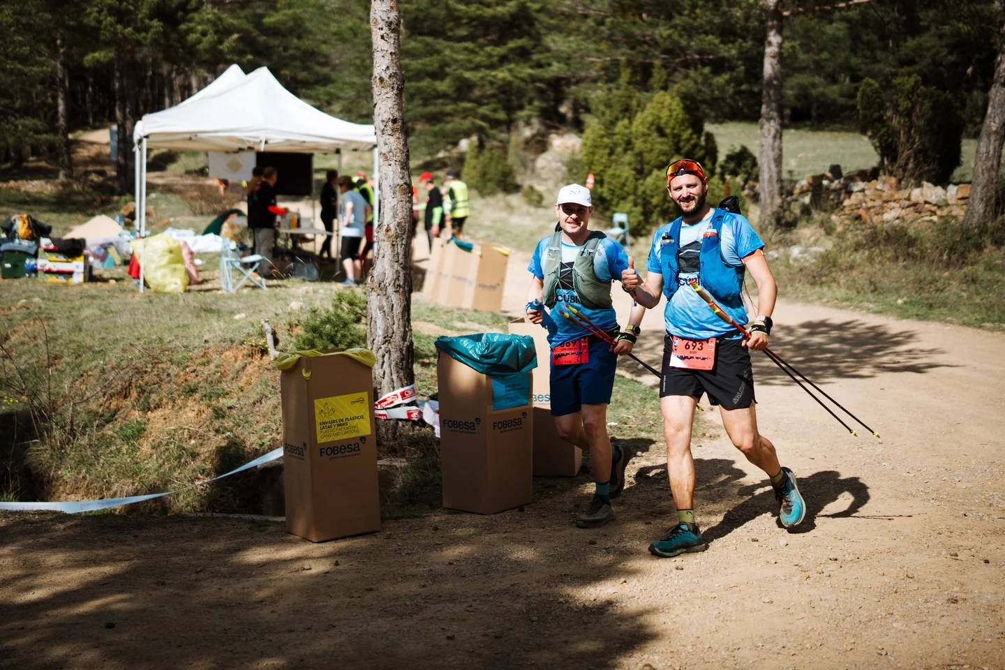 Corredores junto a contenedores de reciclaje en un avituallamiento