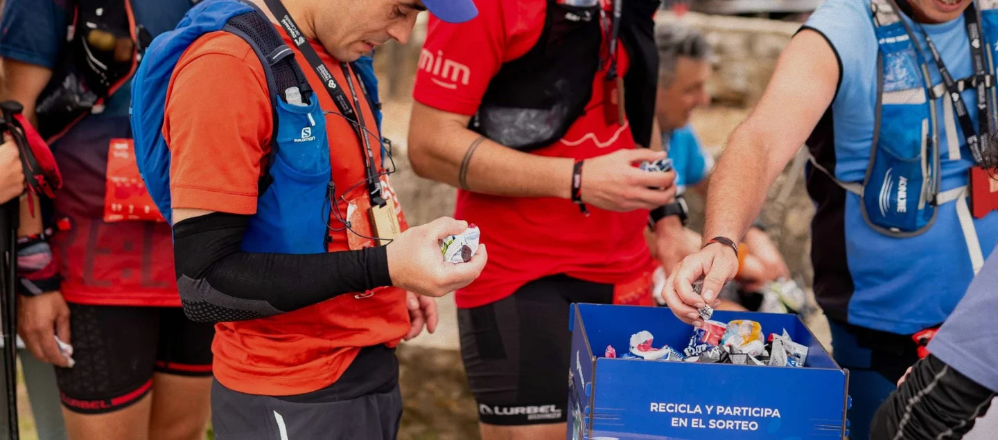 Participantes depositando sus residuos en una caja de recogida en meta