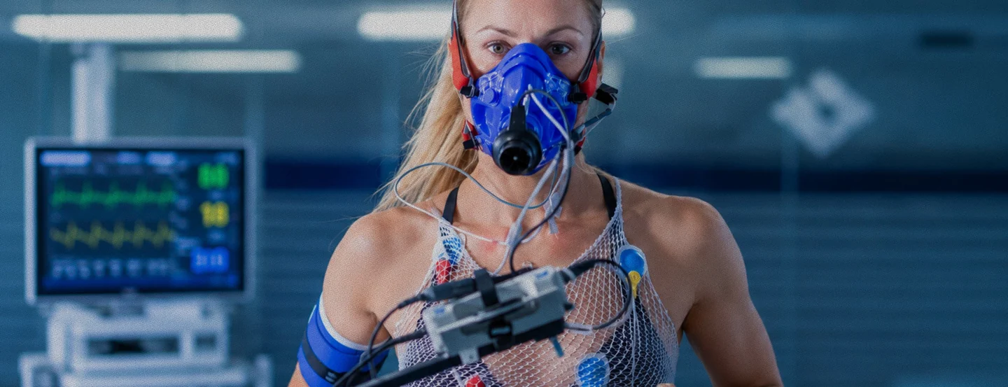 Deportista con máscara de medición respiratoria y sensores durante una prueba de esfuerzo