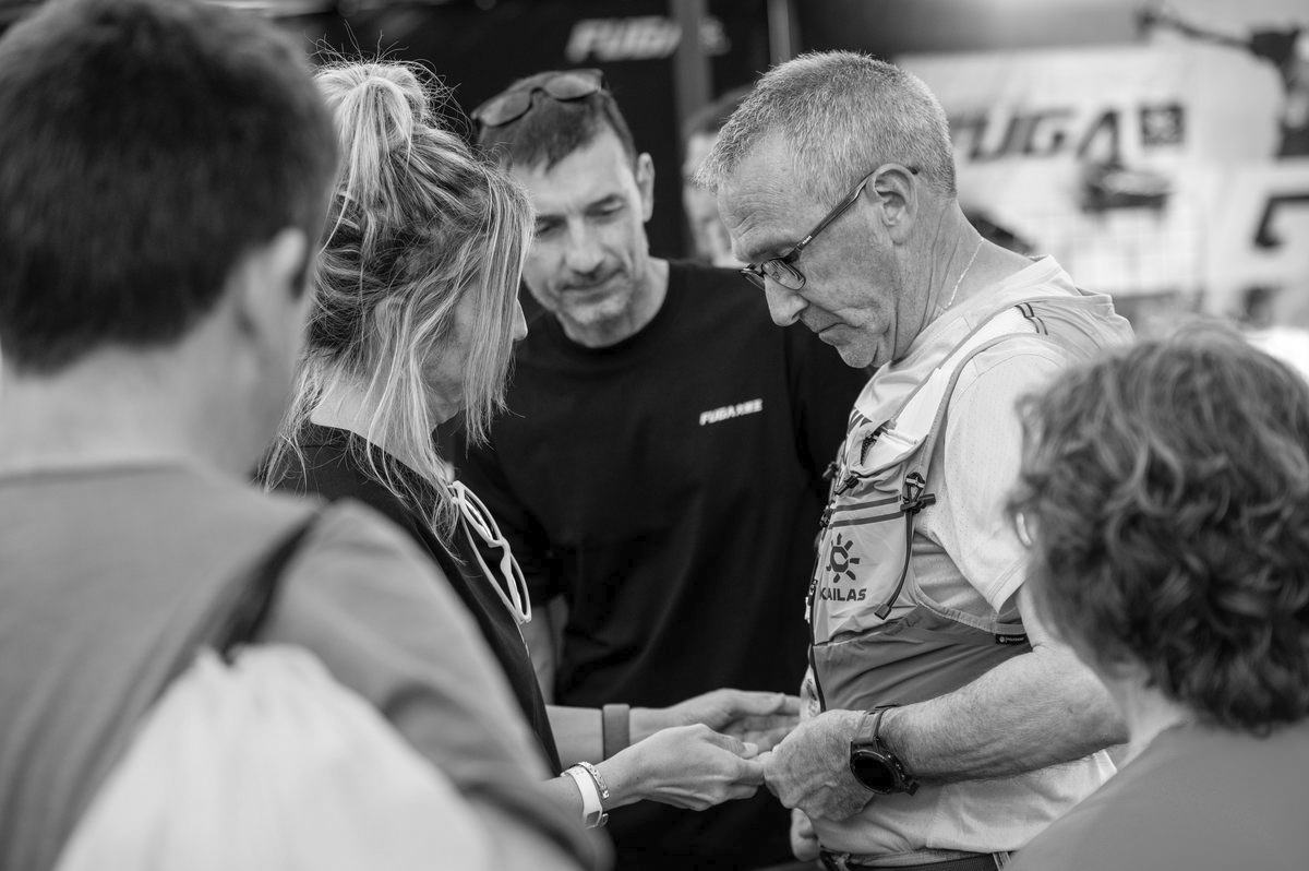 Varias personas reunidas durante la carrera, en una fotografía en blanco y negro